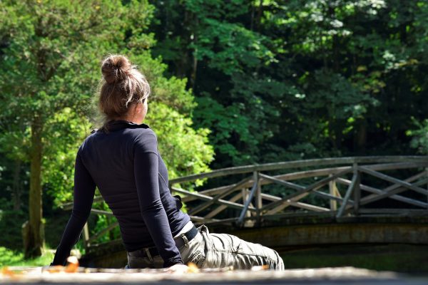 silviarita Foto einer Frau, die nachdenklich an einem Fluss sitzt