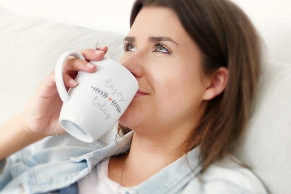 silviarita_selfcare Foto einer Frau, die zurückgelehnt aus ihrer Kaffeetasse trinkt.